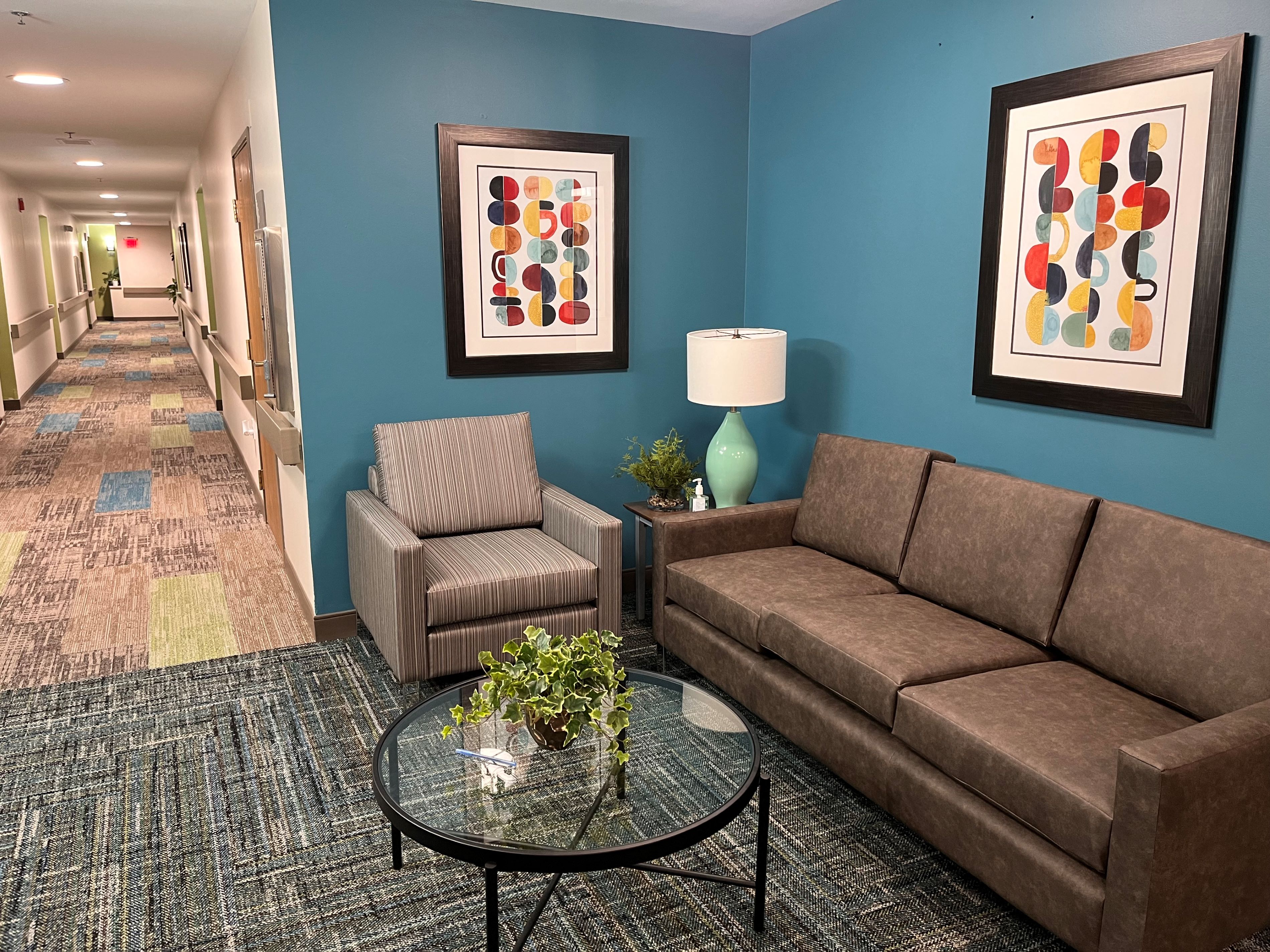 a living room with blue walls and a couch and a chair